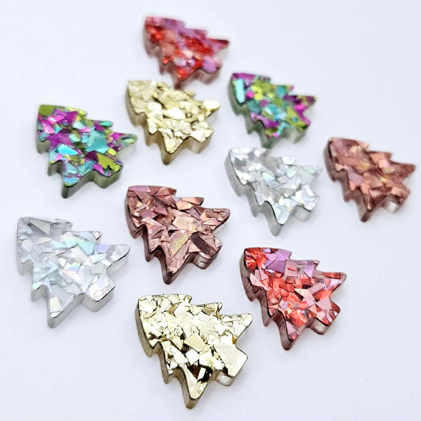 Chunky glitter acrylic 16mm Christmas tree stud earring blanks in a mix of colourful sparkling finishes laying flat.