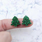 One pair of 16mm green glitter acrylic Christmas tree stud earring blanks – shown on a finger for size reference.