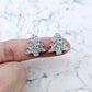 One pair of silver glitter acrylic 16mm Christmas tree stud blanks, shown on a finger for size reference.