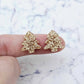 One pair of rose gold glitter acrylic 16mm Christmas tree stud blanks, shown on a finger for size reference.