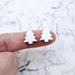 One pair of 12mm solid white acrylic Christmas tree stud earring blanks shown on a finger for size reference.