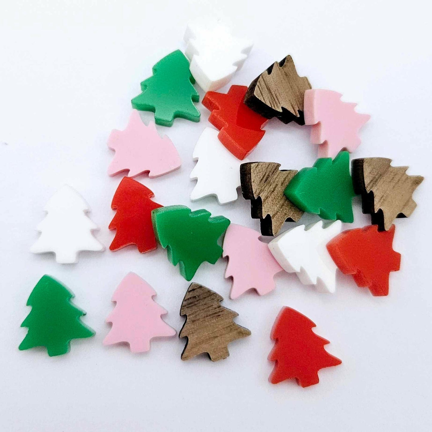 20 pieces of 12mm Christmas tree stud earring blanks in red, green, white and pastel pink solid acrylic and walnut veneer piled together.