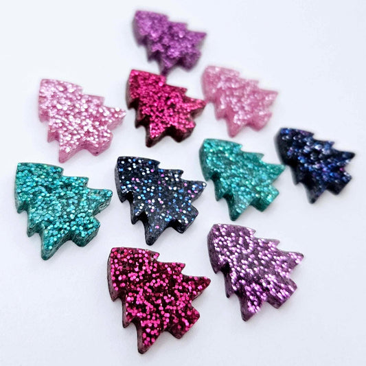 Five colours of 16mm glitter Christmas tree stud earring blanks in hot pink, teal, purple, pink and holographic blue acrylic laying flat.