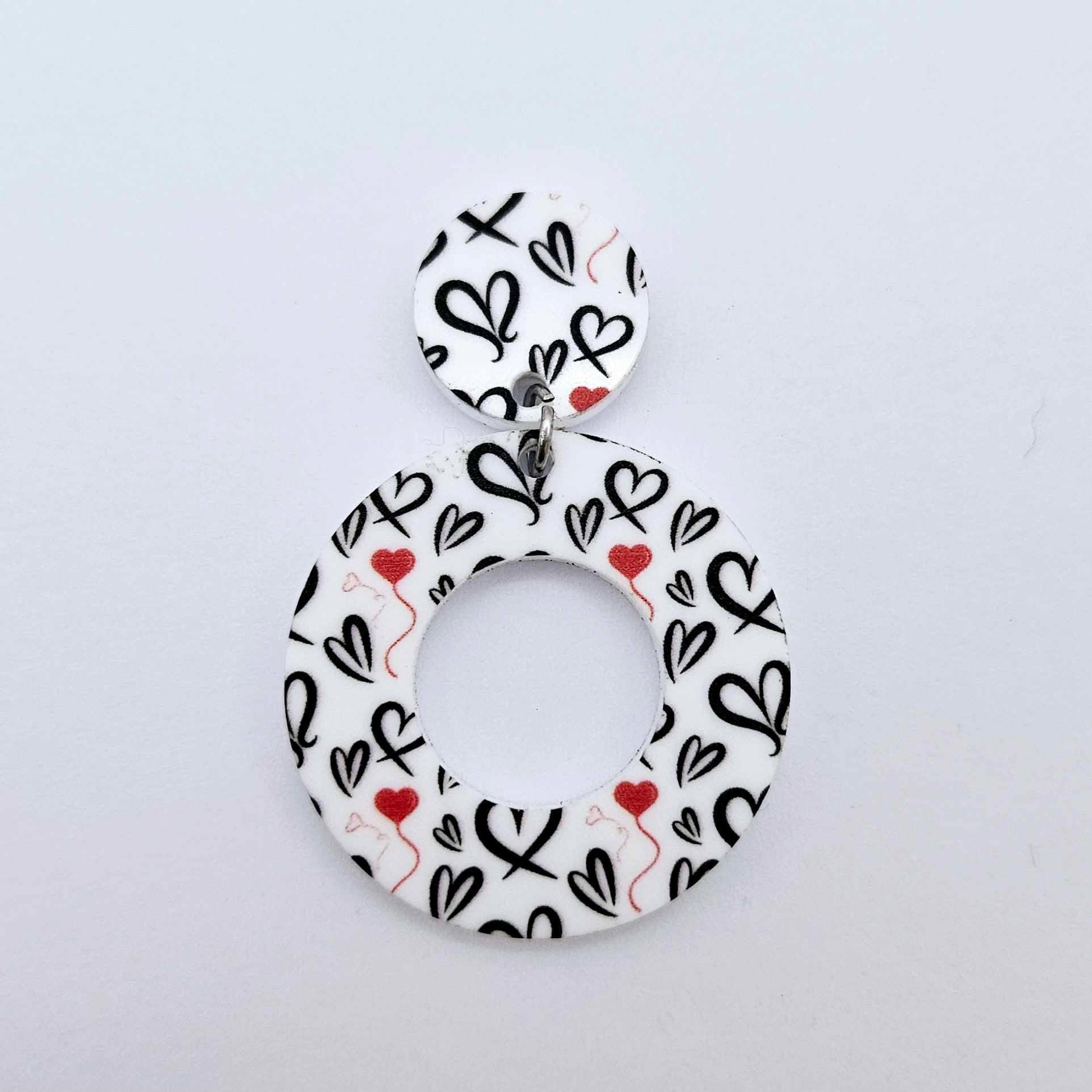 One 33mm Black & Red Hearts UV printed acrylic mini hoop dangle assembled with its matching included topper to show the completed earring design.