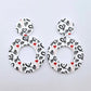One pair of 33mm Black & Red Hearts UV printed acrylic mini hoop dangle earring blanks with matching toppers laying flat.