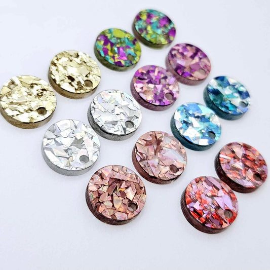 14mm chunky glitter acrylic earring toppers in gold, holographic silver, holographic rose gold, love, peacock, unicorn and aqua, with one pair of each colour laid flat together.