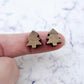 One pair of 12mm walnut veneer Christmas tree stud earring blanks shown on a finger for size reference.