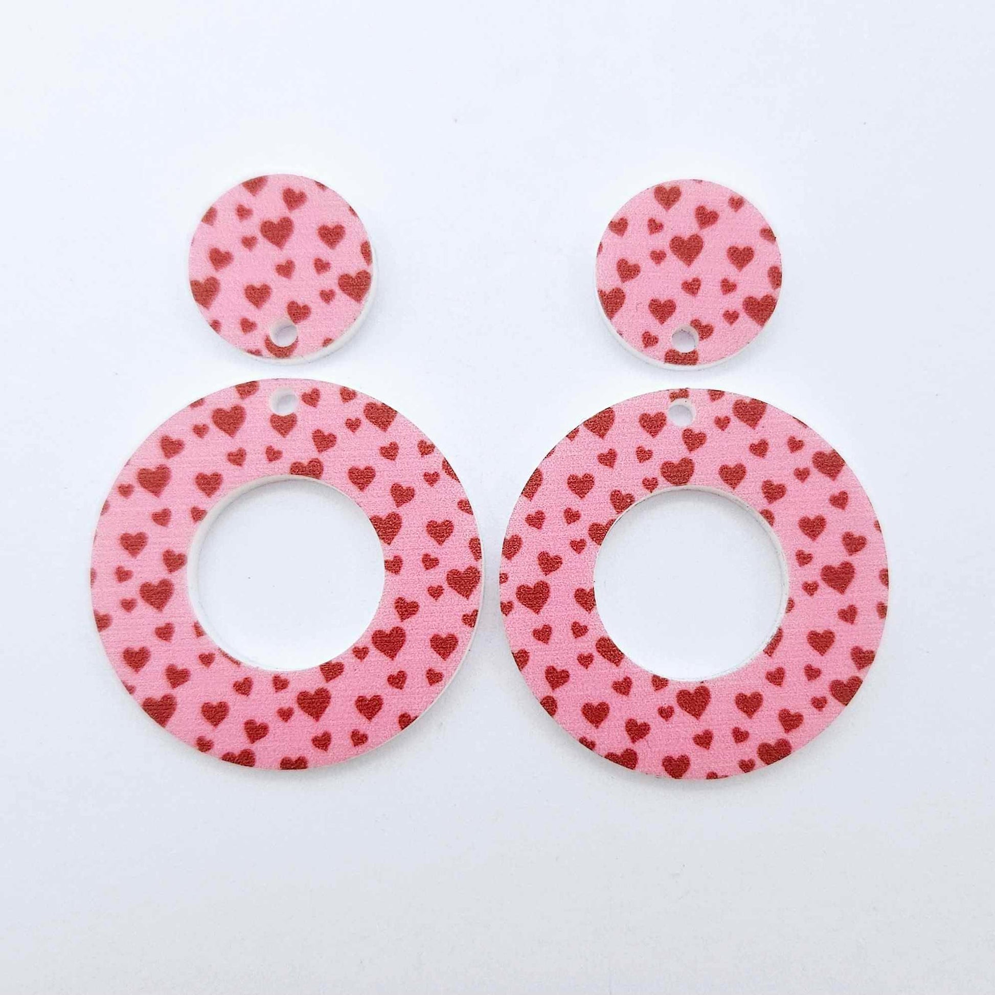 One pair of 33mm Pink & Red Hearts UV printed acrylic mini hoop dangle earring blanks with matching toppers laying flat.