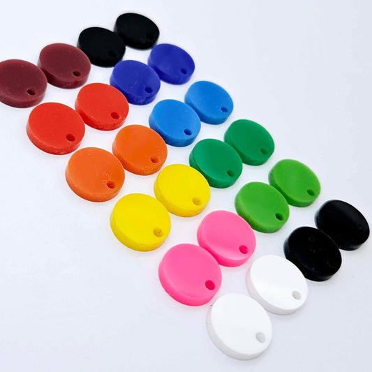 14mm solid acrylic circle earring toppers in white, hot pink, yellow, orange, red, port wine, glossy black, lime green, green, sky blue, dark blue, and matte black with the colour range laid flat together.