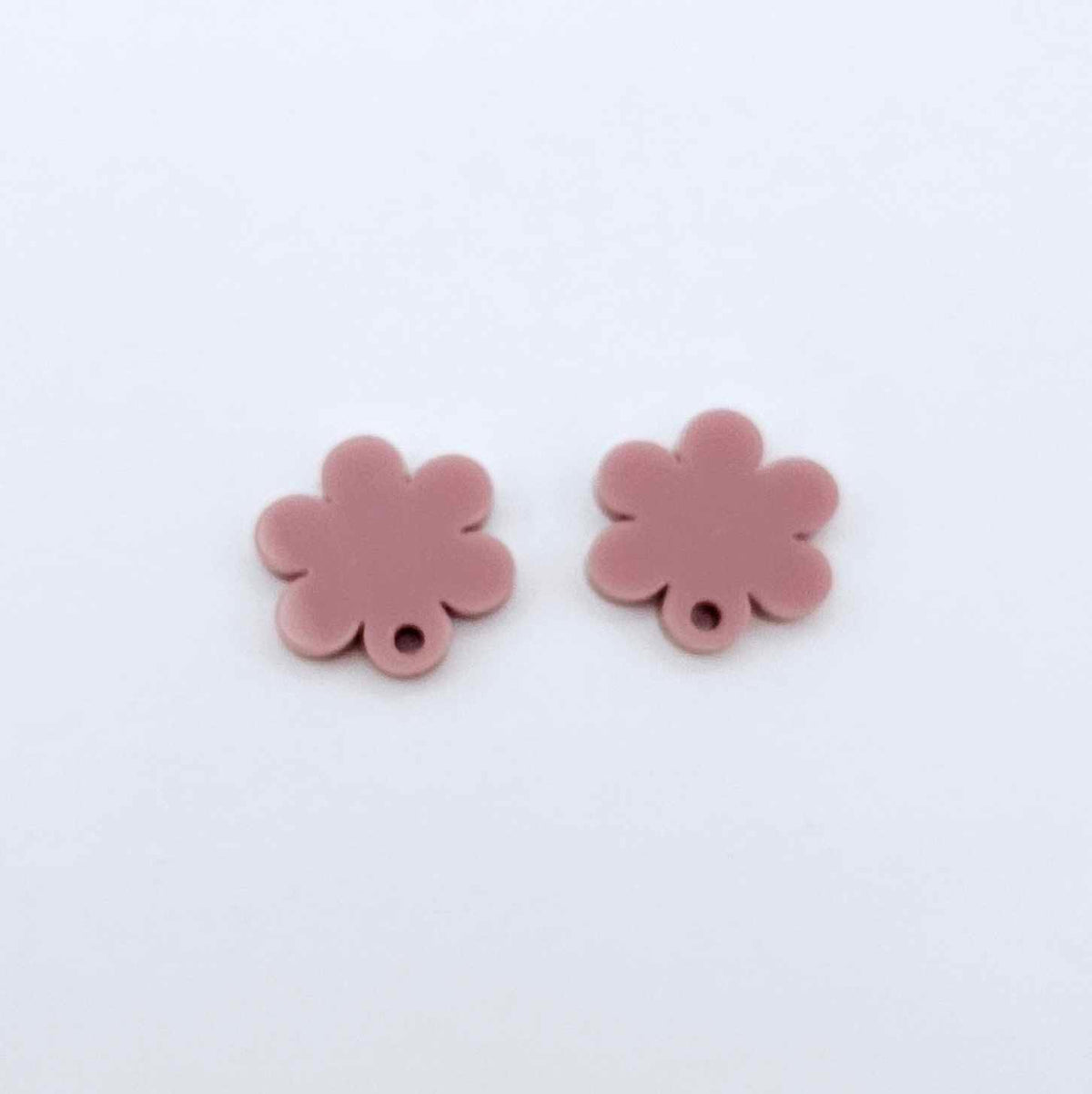 One pair of 14mm dusty rose pink acrylic flower earring topper blanks laying flat.