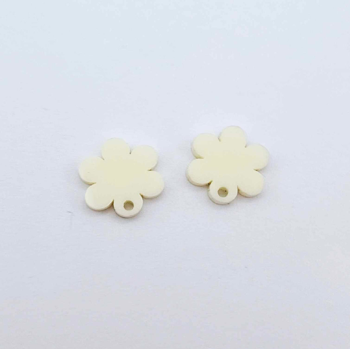 One pair of 14mm cream acrylic flower earring topper blanks laying flat.