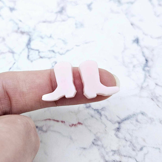 One pair of 15mm strawberry milkshake pink acrylic boot stud earring blanks shown on a finger for size reference.