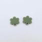 One pair of 14mm olive green acrylic flower earring topper blanks laying flat.