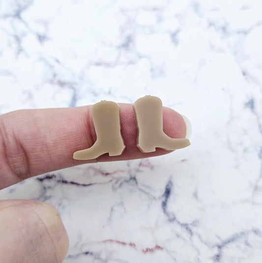 One pair of 15mm iced coffee acrylic boot stud earring blanks shown on a finger for size reference.
