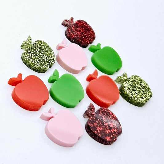 14mm apple acrylic earring stud blanks in red, lime green, pastel pink, red glitter and light green glitter laid flat together.
