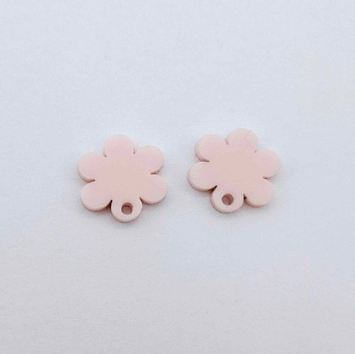 One pair of 14mm strawberry milkshake pink acrylic flower earring topper blanks laying flat.