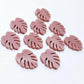 17mm dusty rose pink acrylic monstera leaf acrylic stud earring blanks laid flat together.