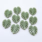 17mm olive green acrylic monstera leaf acrylic stud earring blanks laid flat together.
