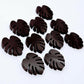 17mm chocolate brown acrylic monstera leaf stud earring blanks laid flat together.