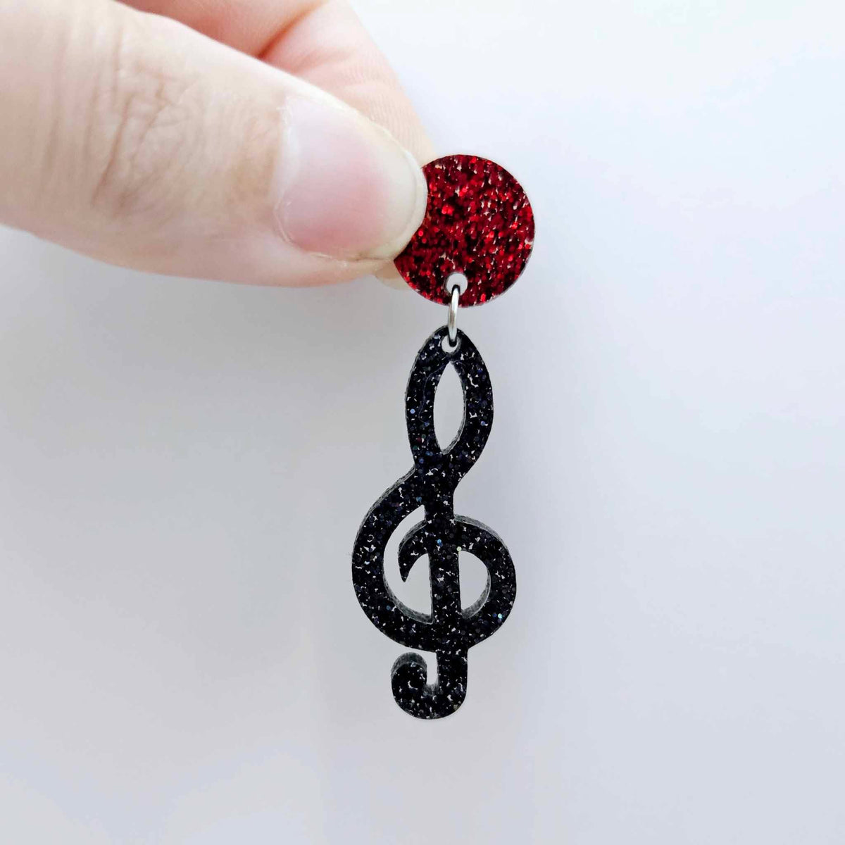 40mm holographic black glitter treble clef earring dangle blank assembled with a 14mm red glitter topper, showing how the pieces can be paired to create a finished music inspired earring.