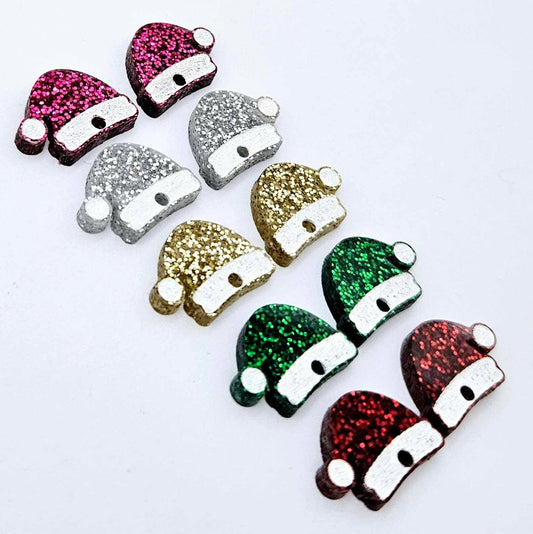 A selection of paint-filled glitter acrylic Santa hat toppers in red, green, gold, silver and hot pink