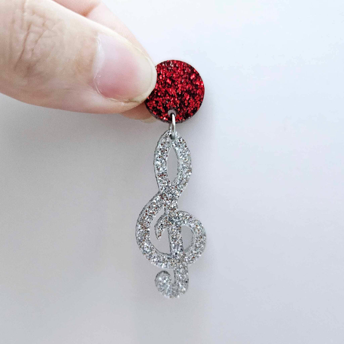 40mm silver glitter treble clef earring dangle blank assembled with a 14mm red glitter topper, showing how the pieces can be paired to create a finished music inspired earring.