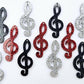 40mm glitter treble clef earring dangle blanks in silver glitter, red glitter and holographic black glitter, laid flat together.
