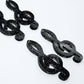 Two pairs of 40mm holographic black glitter acrylic treble clef earring dangle blanks laid flat.