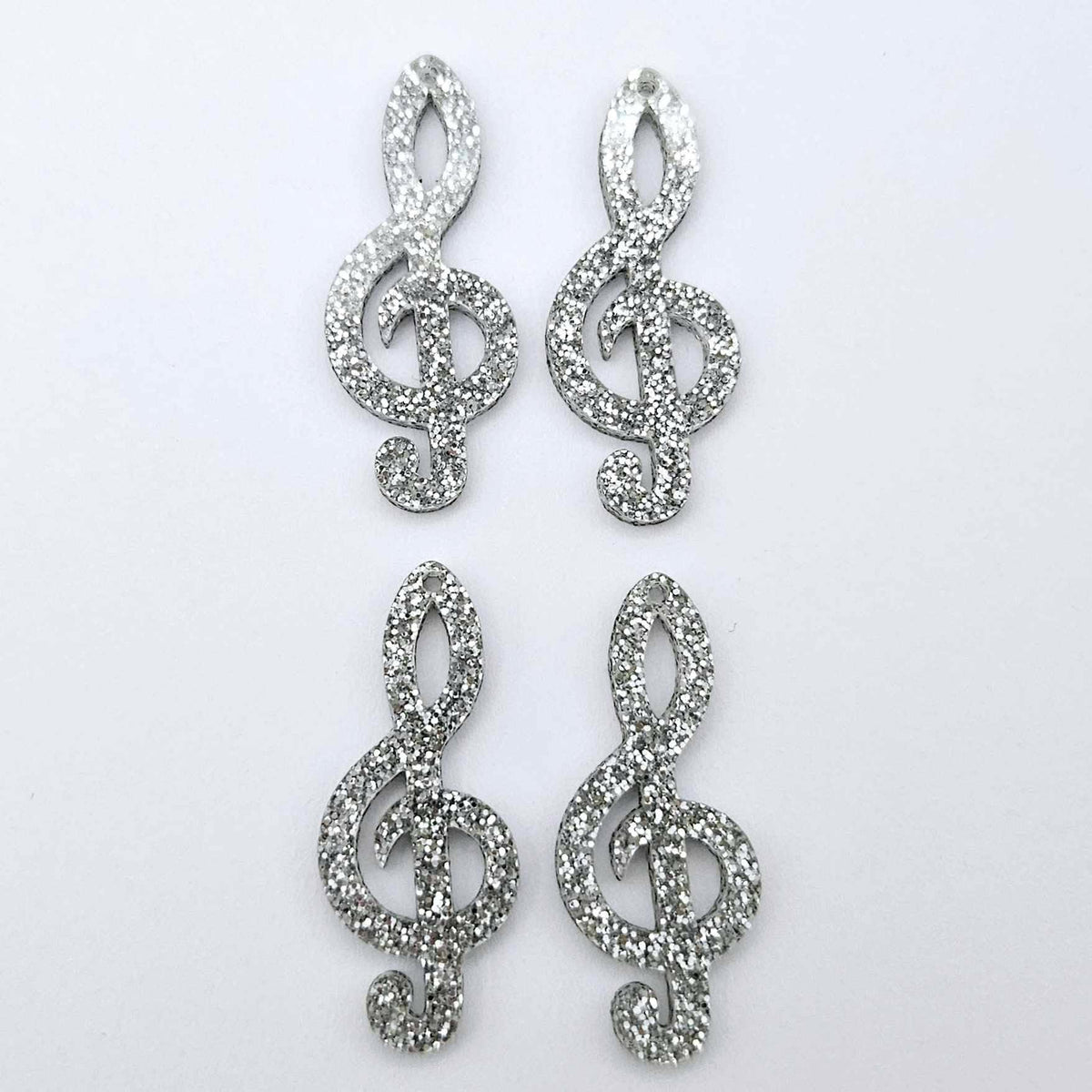40mm silver glitter acrylic treble clef earring dangle blanks laid flat together.