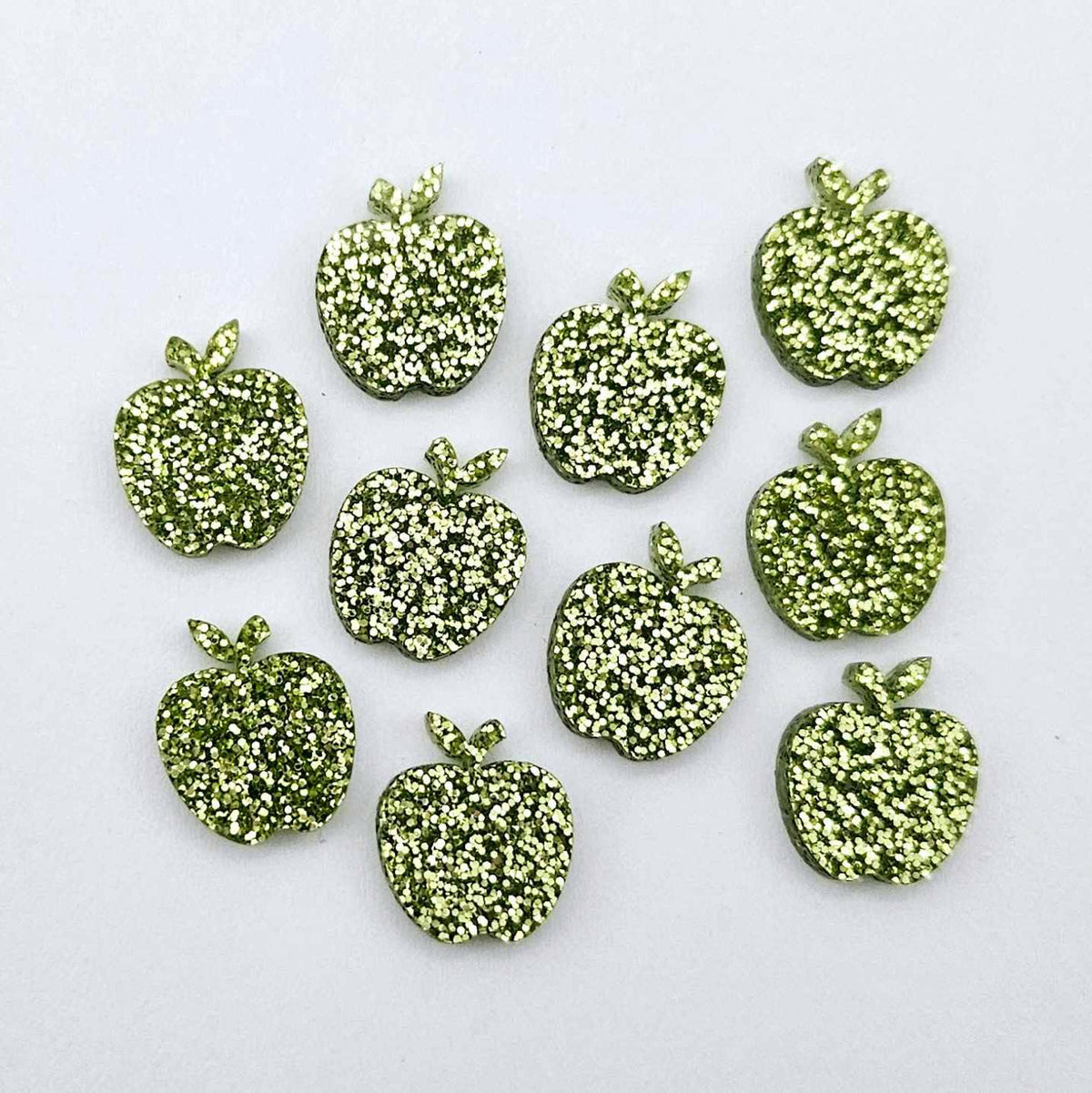 14mm light green glitter acrylic apple earring stud blanks laid flat together.