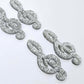 40mm silver glitter acrylic treble clef earring dangle blanks laid flat together.