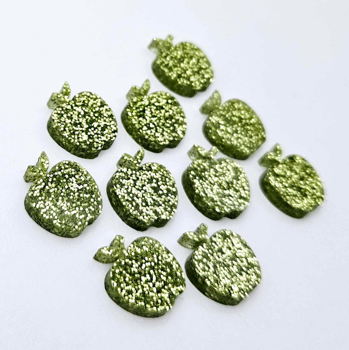 14mm light green glitter acrylic apple earring stud blanks laid flat together.