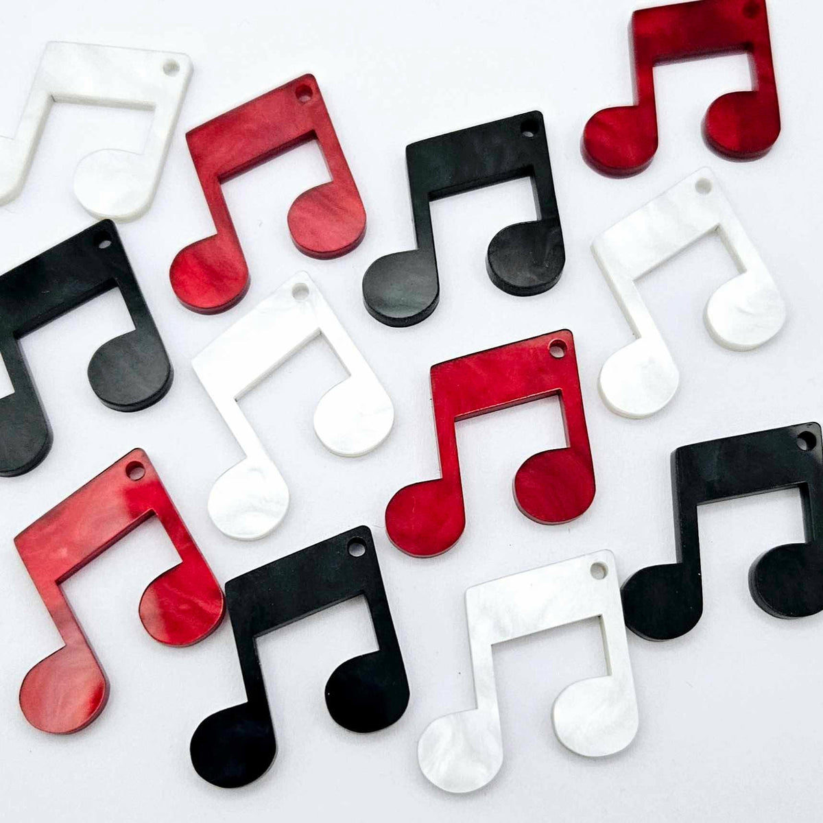 35mm marble music note earring dangle blanks in red, black and white marble acrylic, with two pairs of each colour laid flat together.