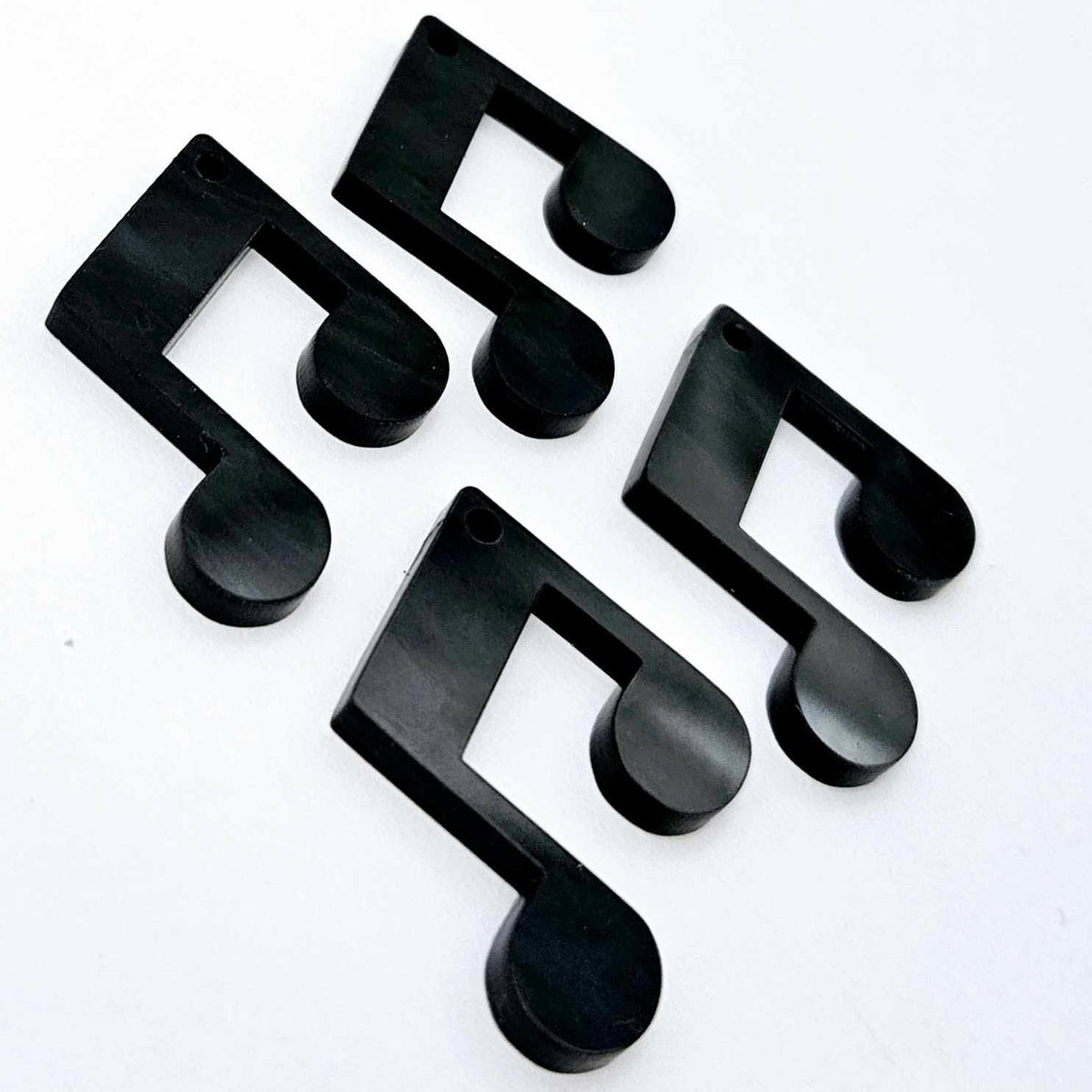 Two pairs of 35mm black marble acrylic music note earring dangle blanks laid flat together.