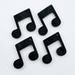 Two pairs of 35mm black marble acrylic music note earring dangle blanks laid flat together.