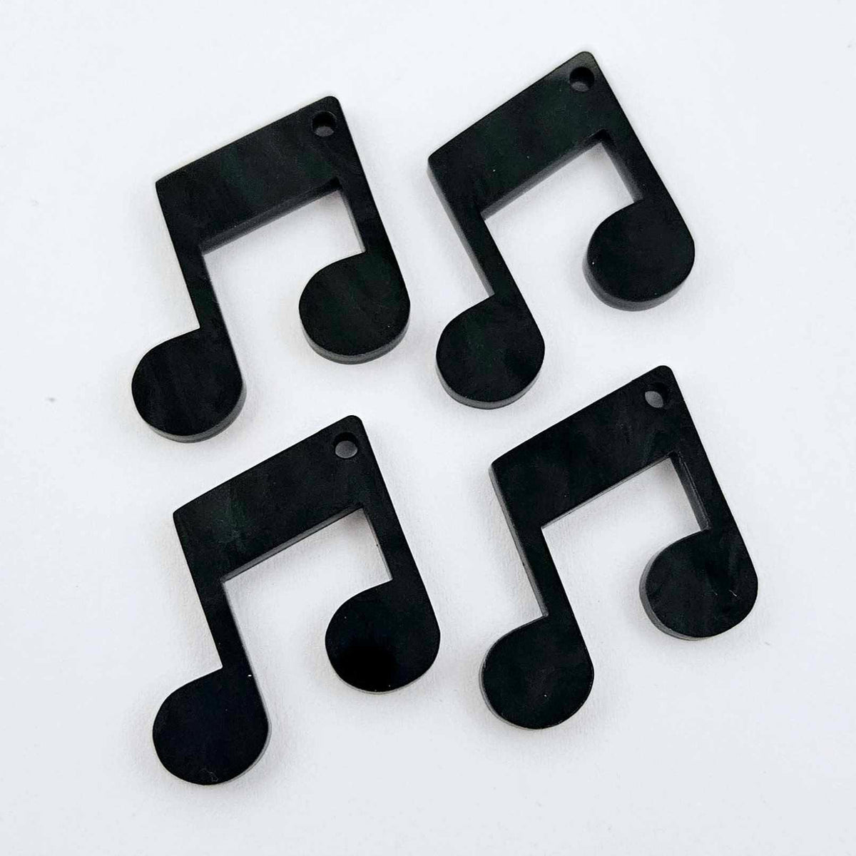 Two pairs of 35mm black marble acrylic music note earring dangle blanks laid flat together.