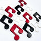 35mm marble music note earring dangle blanks in red, black and white marble acrylic, with two pairs of each colour laid flat together.