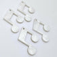 Two pairs of 35mm white marble acrylic music note earring dangle blanks laid flat together.
