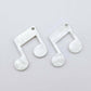 One pair of 35mm white marble acrylic music note earring dangle blanks laid flat together.