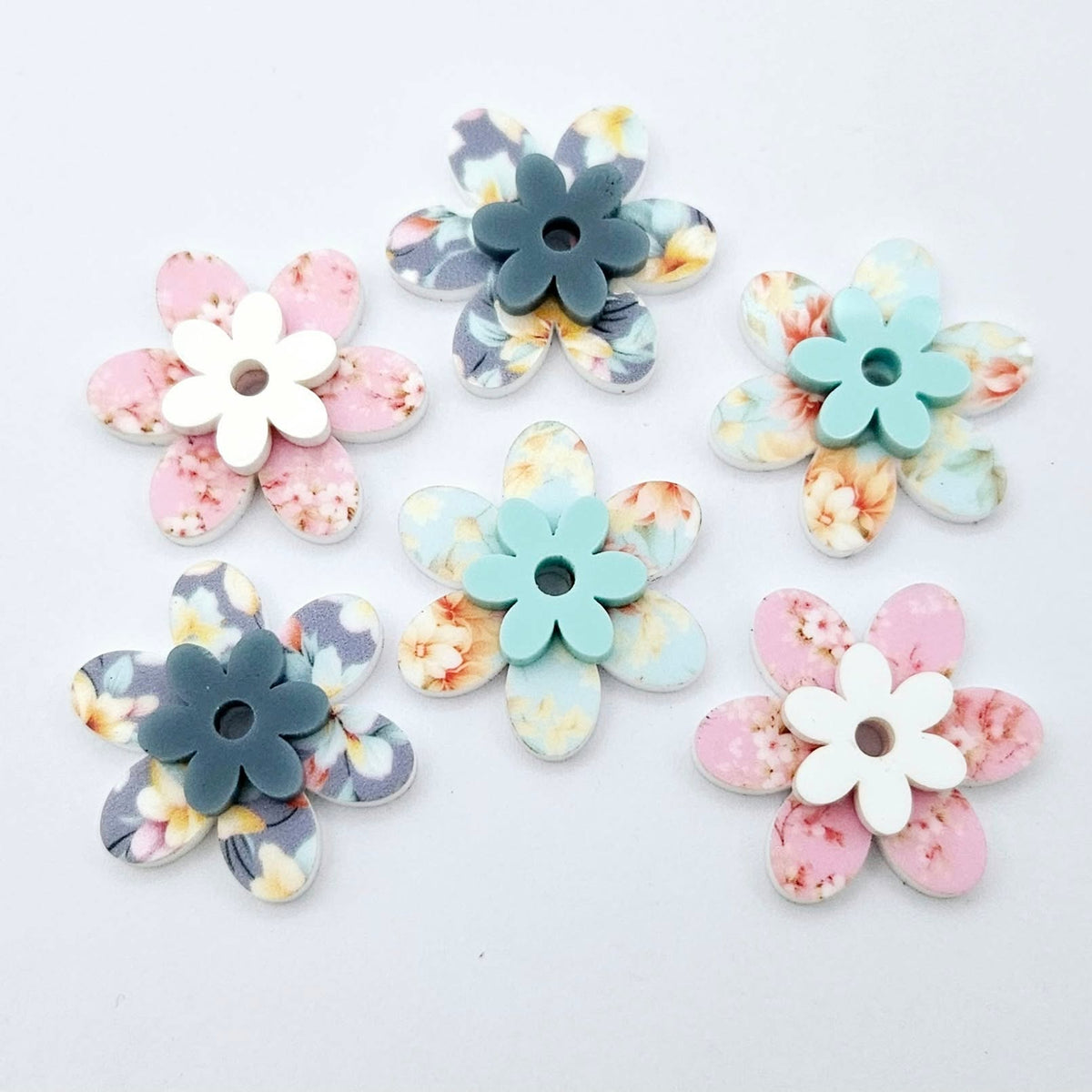 UV printed acrylic flower earring blanks in Cherry Blossom and White, Floral Bloom and Pastel Aqua, and Hawaii Dream and Bluestone, featuring two-piece floral designs made for 20mm hoop earrings.