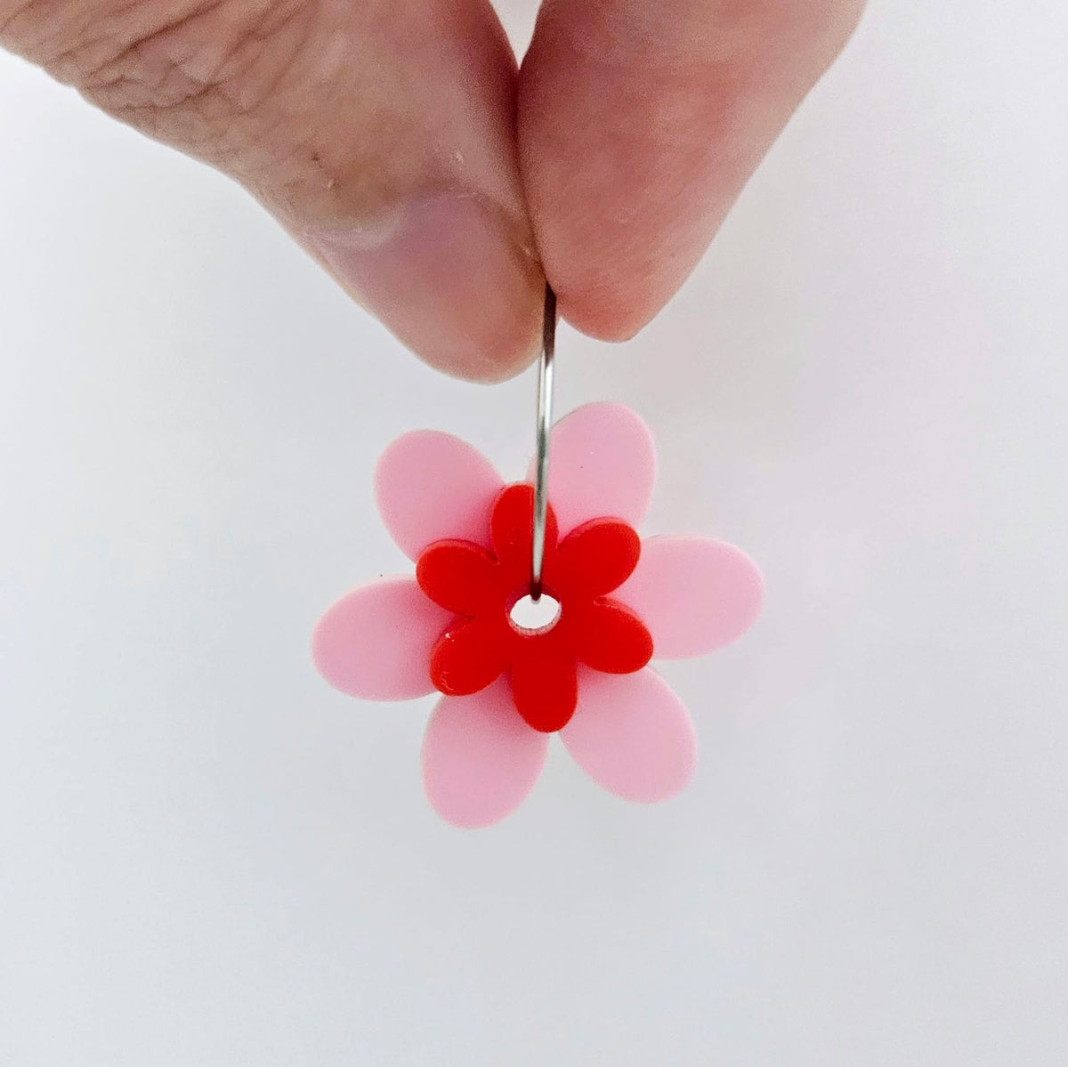 Two-piece pastel pink and red solid colour acrylic flower earring blanks assembled on 20mm stainless steel hoop, showing how the layered floral pieces create lightweight statement earring.