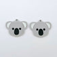 Pair of solid grey acrylic koala dangle blanks laid flat, featuring engraved eyes, nose and inner ear details paint filled with black and white for a cute Australiana earring design.