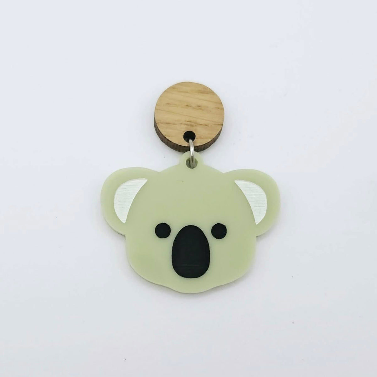 Solid eucalyptus green acrylic koala dangle earring blank assembled with a 14mm Oak wooden topper, featuring black paint-filled eyes and nose with white inner ears, showing how the pieces can be combined to create a finished koala earring.