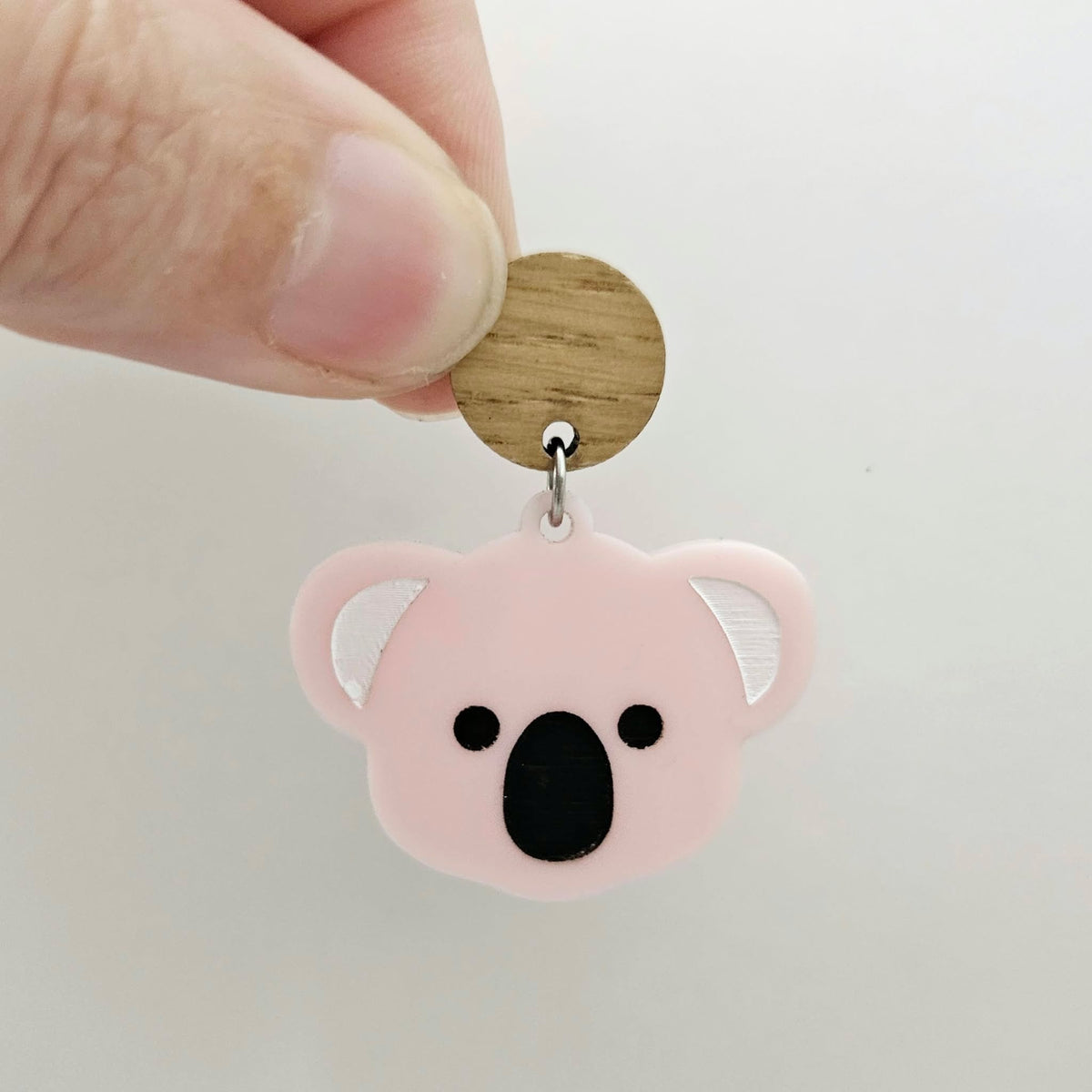 Solid strawberry milkshake pink acrylic koala dangle earring blank assembled with a 14mm Oak wooden topper, featuring black paint-filled eyes and nose with white inner ears, showing how the pieces can be combined to create a finished koala earring.
