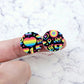 One pair of 20mm Neon Pride UV printed acrylic stud earring blanks displayed on a finger to show their size, perfect for creating fun statement stud earrings.