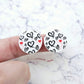 One pair of 20mm Black & Red Hearts UV printed acrylic stud earring blanks displayed on a finger to show their size, perfect for creating fun statement stud earrings.